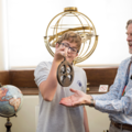 Staff showing student an astrolabe