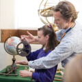 Staff showing student how to use an astrolabe