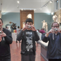 Three men taking photographs in a gallery