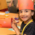 Young girl making a paper crown 